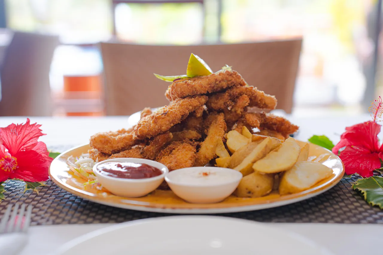 Golden fish and chips served with lemon and dipping sauces