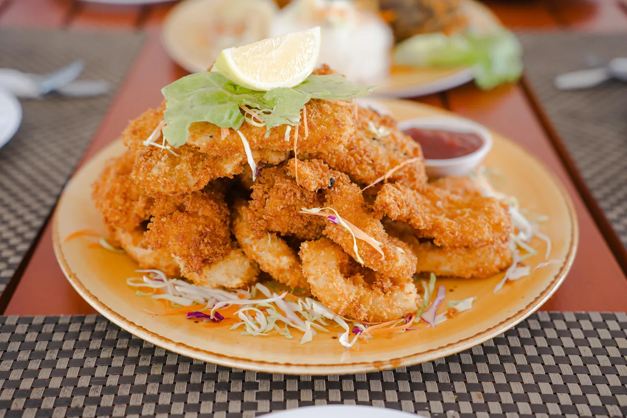 A golden breaded platter with chips, lemon and dipping sauces