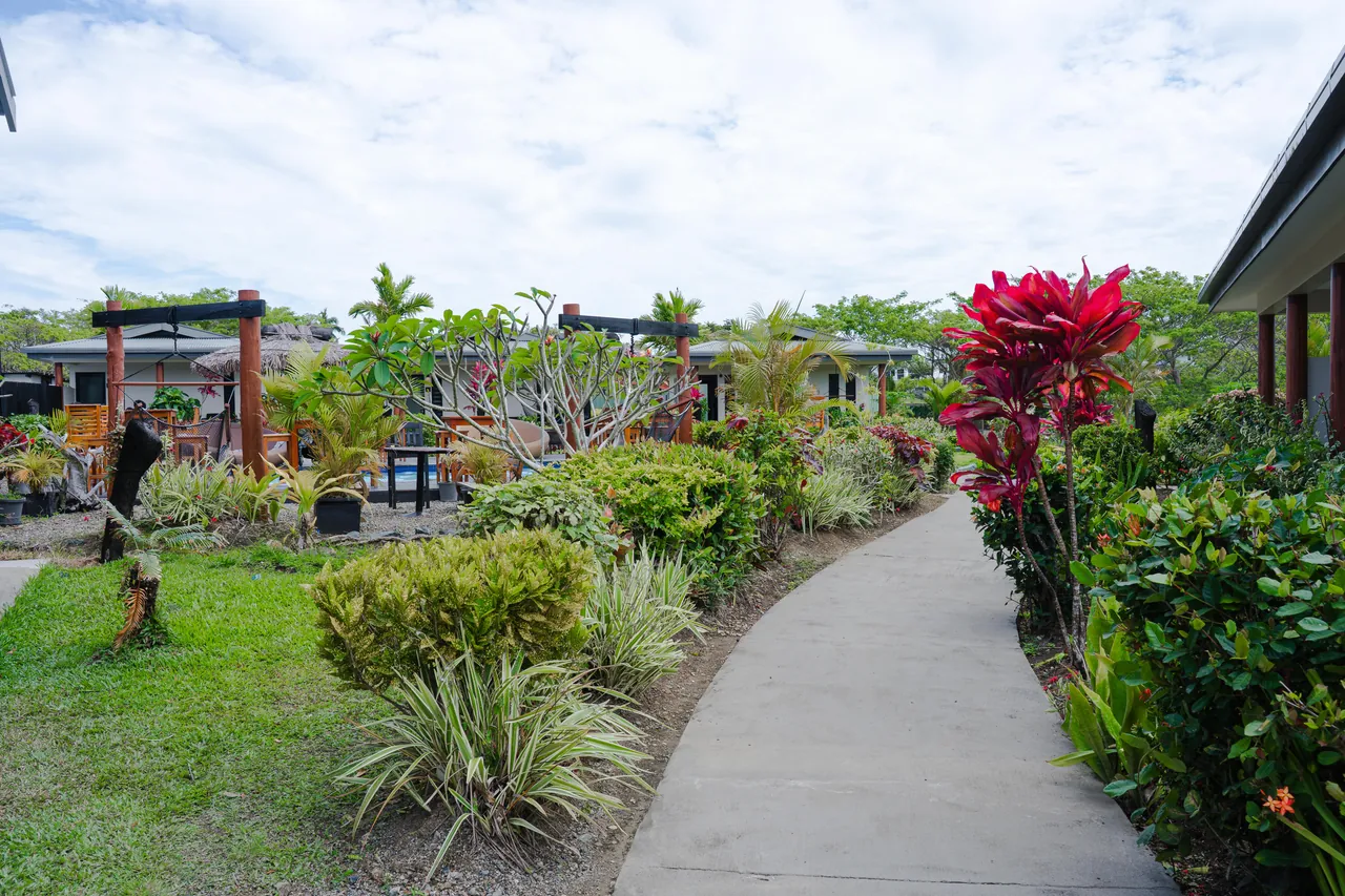 A path winding through tropical gardens beside the villas