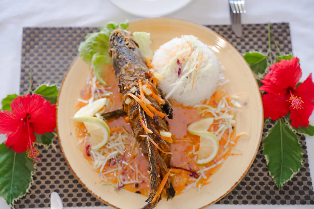 Whole fish served with rice, vegetables and lemon at the restaurant